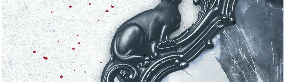 A portion of a broken mirror with an ornamental frame including a cat figurine.