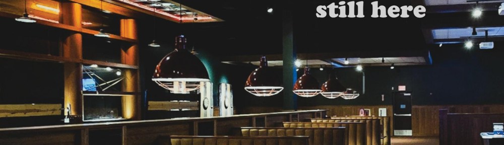 A photo of empty booths in a dark restaurant or bar setting.